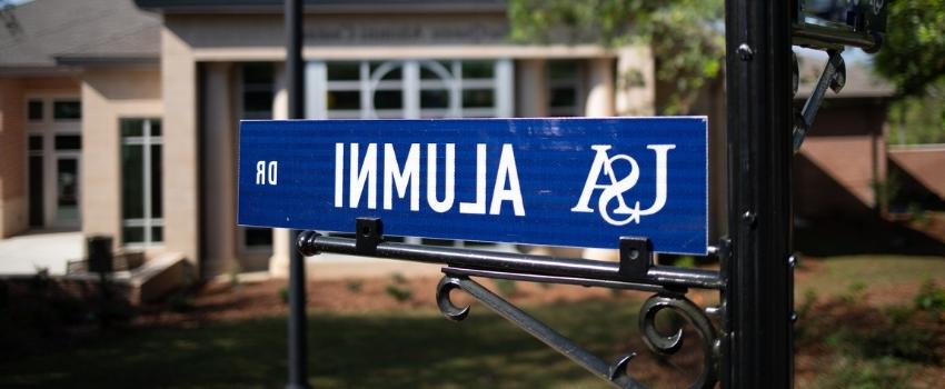Alumni Drive street sign in front of the Alumni Center